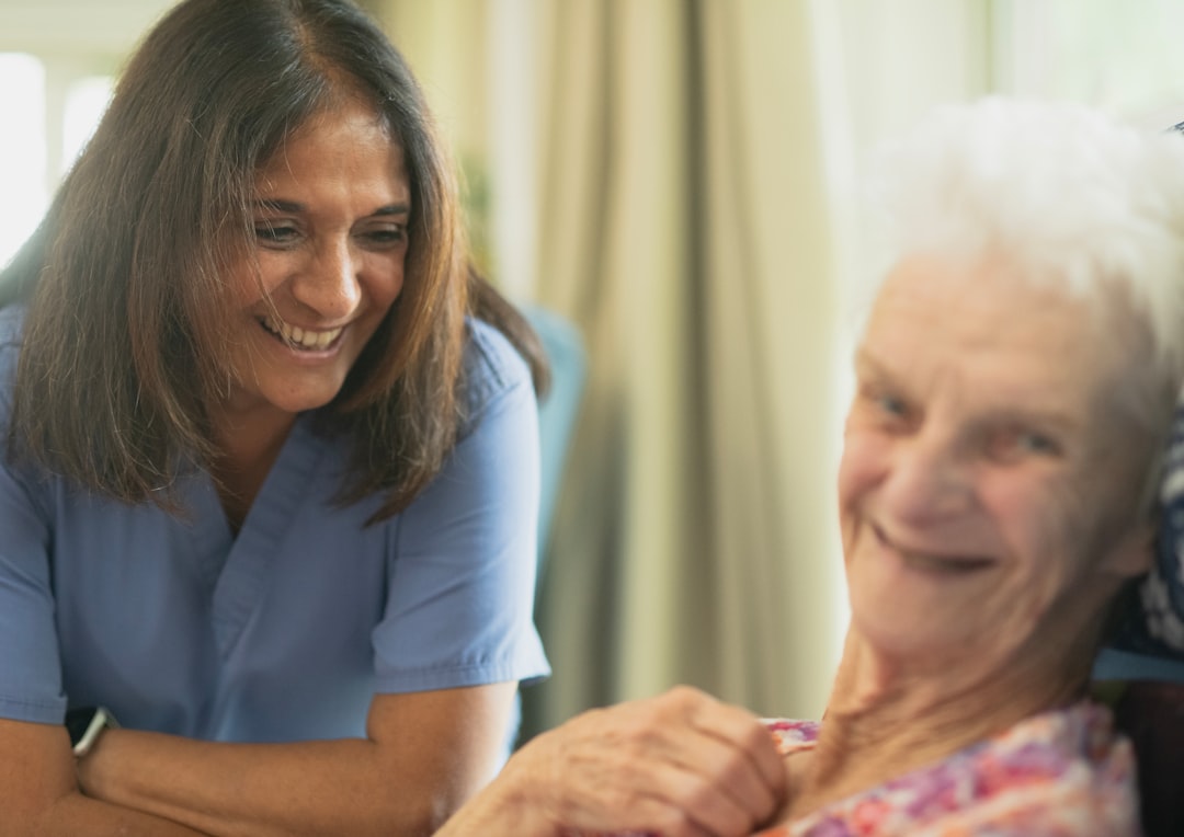 A support worker smiling while sitting with a participant indoors