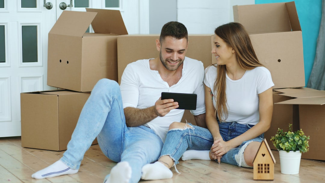 Two people planning a move together among packed boxes in a new home